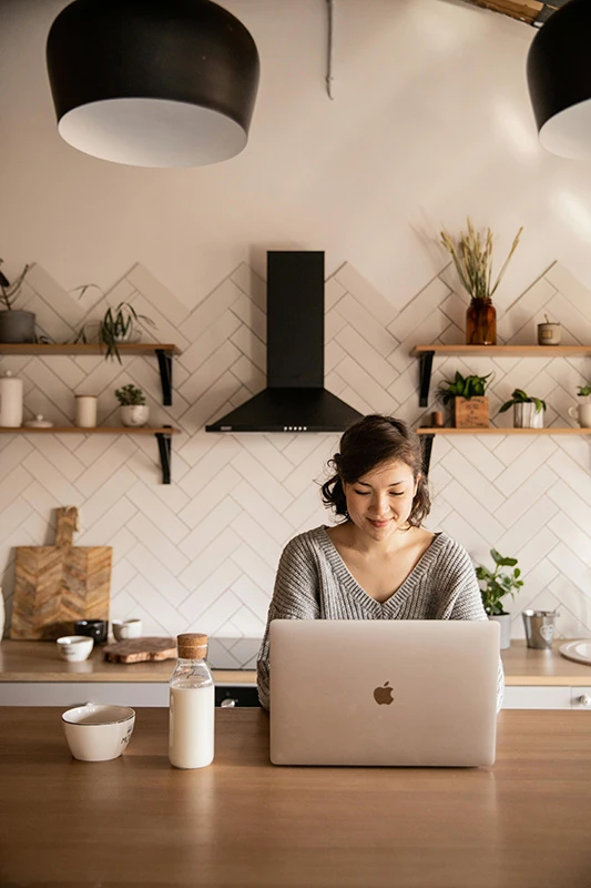 Lady using laptop in kitchen
